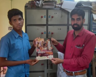 Shri Surojit Mukherjee, senior teacher of Odalchua ST High School, Belpahari, Jhargram handing over a book to Shri Budhrai Mandi