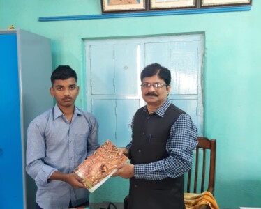 Head Sir of Kokond Kalika Siksha Sadan, Goghat, Shri. Gautam Karak handing over a book to beneficiary Rohit Dey Head Sir of Kokond Kalika Siksha Sadan, Goghat, Shri. Gautam Karak handing over a book to beneficiary Rohit Dey.