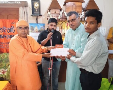 Swami Devyanandaji & our Donor Mr. Sudip Chatterjee handing over a cheque to beneficiary Nayan Samanta