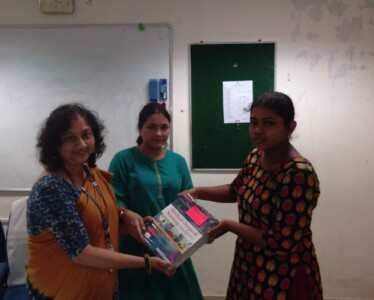 Principal of Peerless Institute of Nursing Ms. Mahuya Karmakar and her colleague handing over nursing books to a beneficiary on behalf of Uma Guha Foundation.