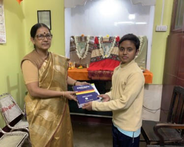 Shri Surojit Mukherjee, senior teacher of Odalchua ST High School, Belpahari, Jhargram handing over a book to Shri Budhrai Mandi